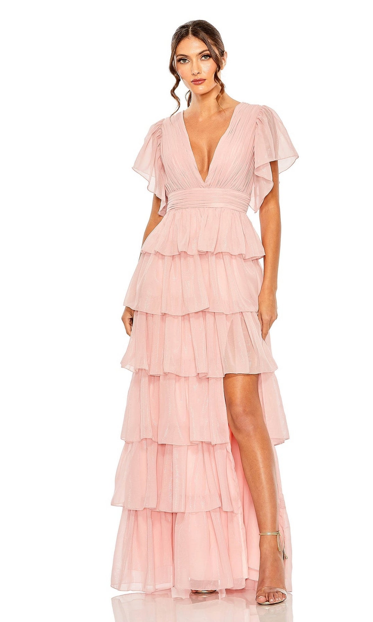 A woman wears the Mac Duggal 49595 Flutter-Sleeve Long Formal Dress in light pink, featuring a deep V-neckline, high slit, and tiered ruffles with strappy heels—an elegant choice for evening events.